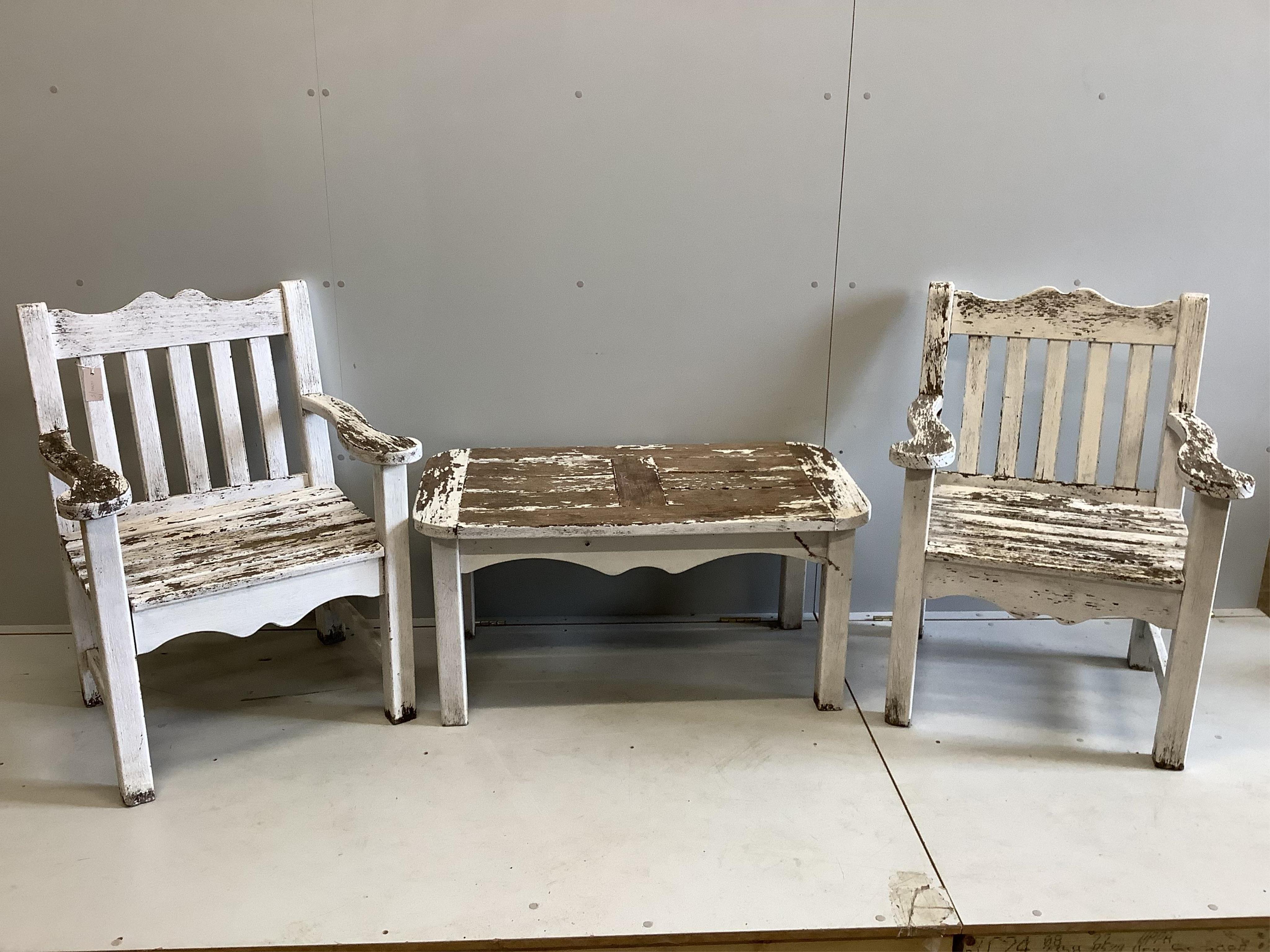 A pair of painted teak garden elbow chairs, width 68cm, depth 56cm, height 90cm and a rectangular coffee table. Condition - fair